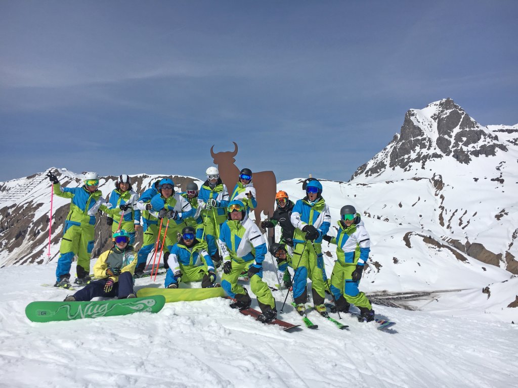 Skilehrerteam auf der Piste mit neuen Skianzügen